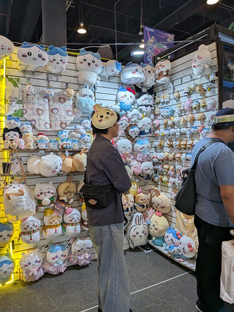 アニモレ会場のグッズショップ。『ちいかわ』のぬいぐるみが壁一面に陳列され、来場者が選んでいる様子