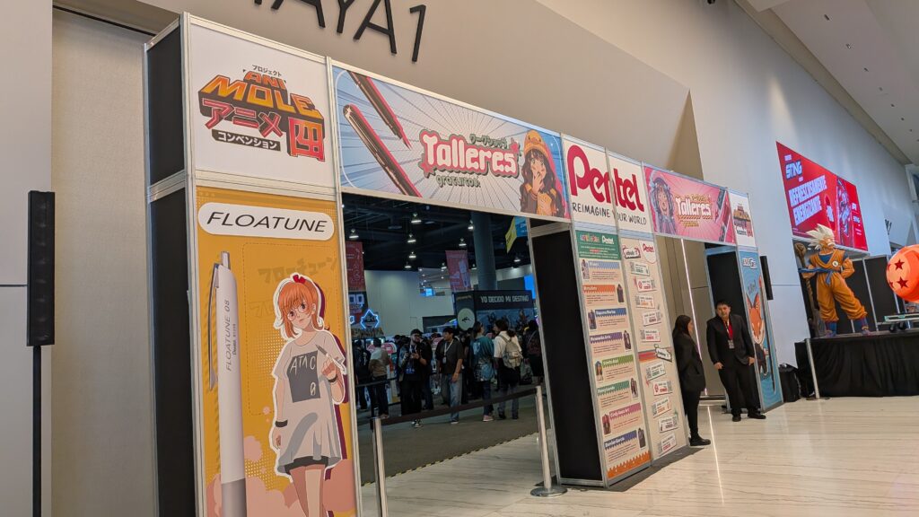 アニモレ(アニメ四)の入り口通路。Pentel、Talleres、フローチューンなどのブース看板とドラゴンボールの立像が並ぶ